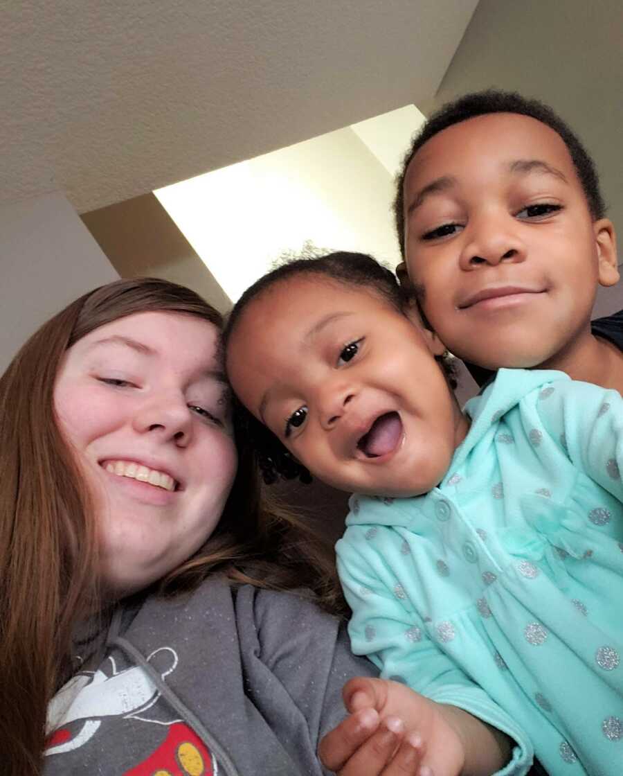 Emma takes a picture with her adopted siblings. 