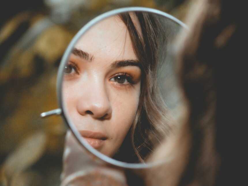 一个女人凝视着镜子里自己的倒影
