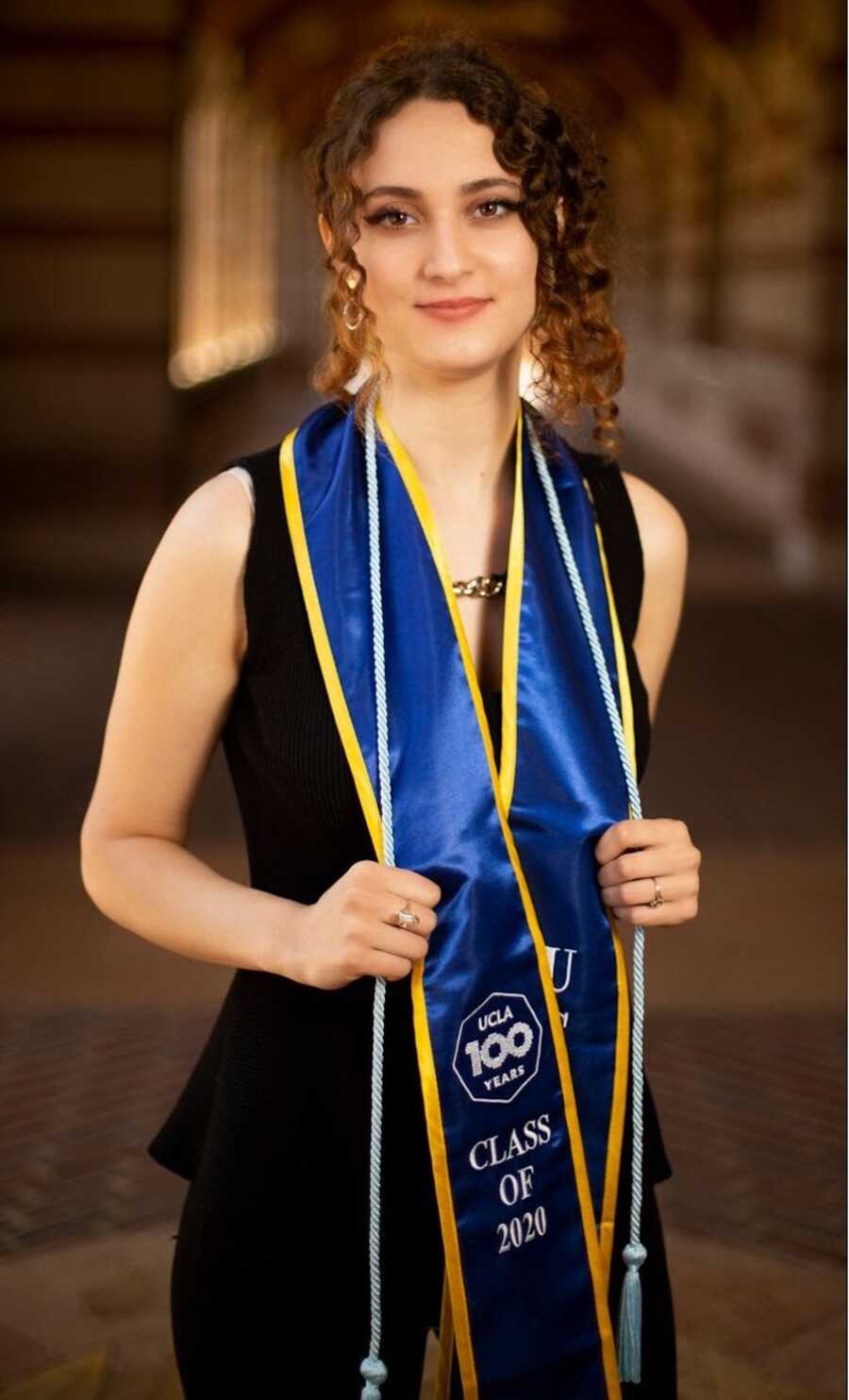 Woman in black dress and graduation ribbon