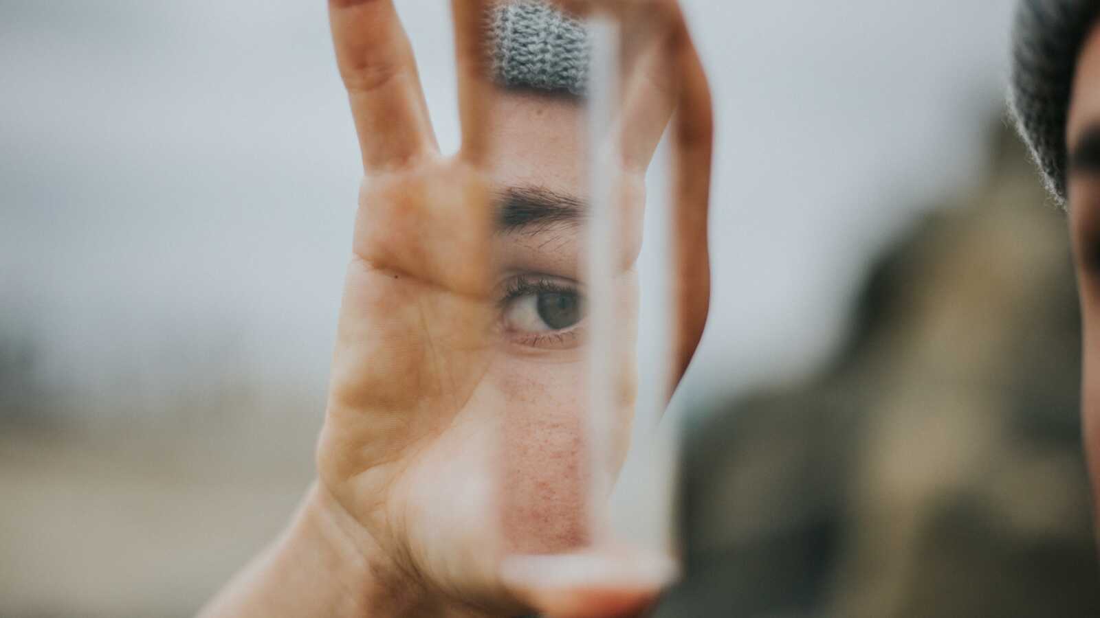 A person holds a reflective item in their hand