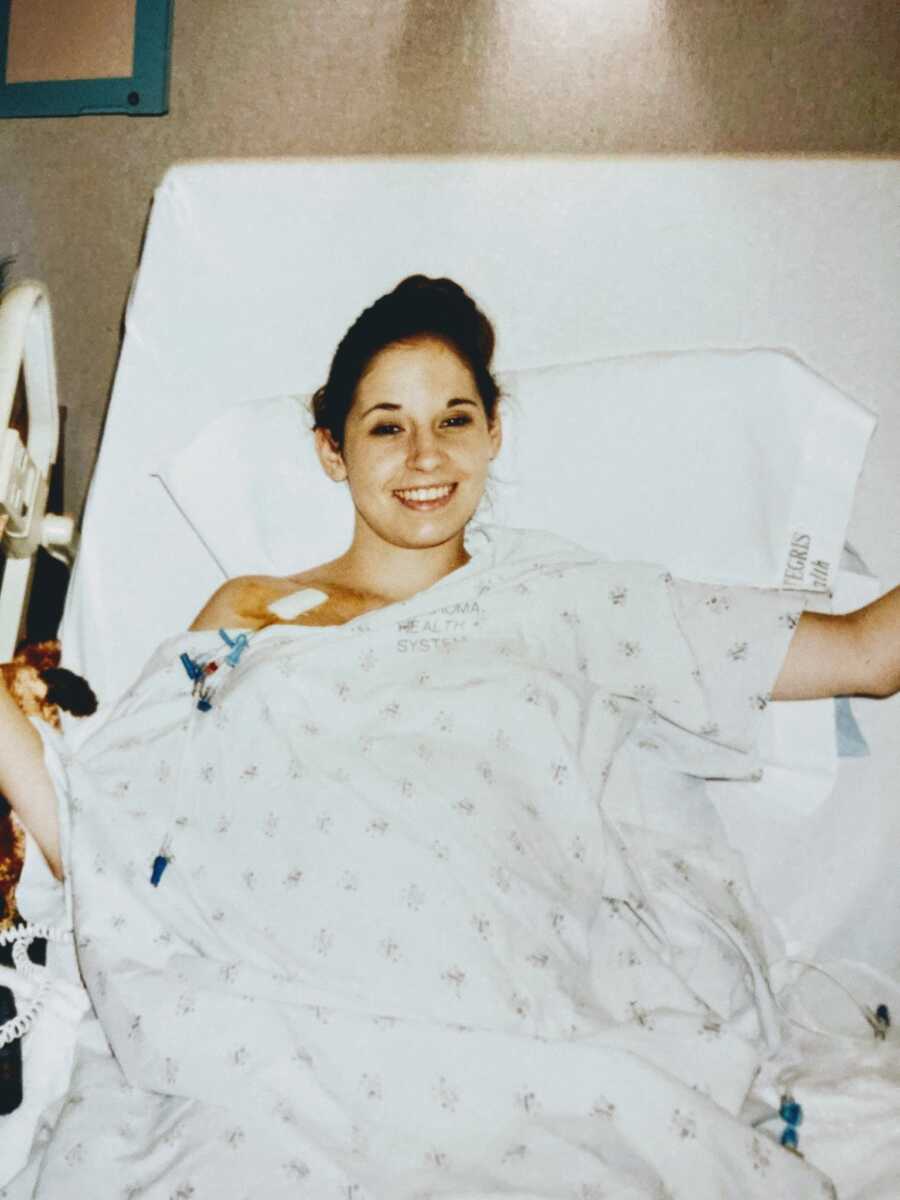 woman post-treatment in hospital bed smiling