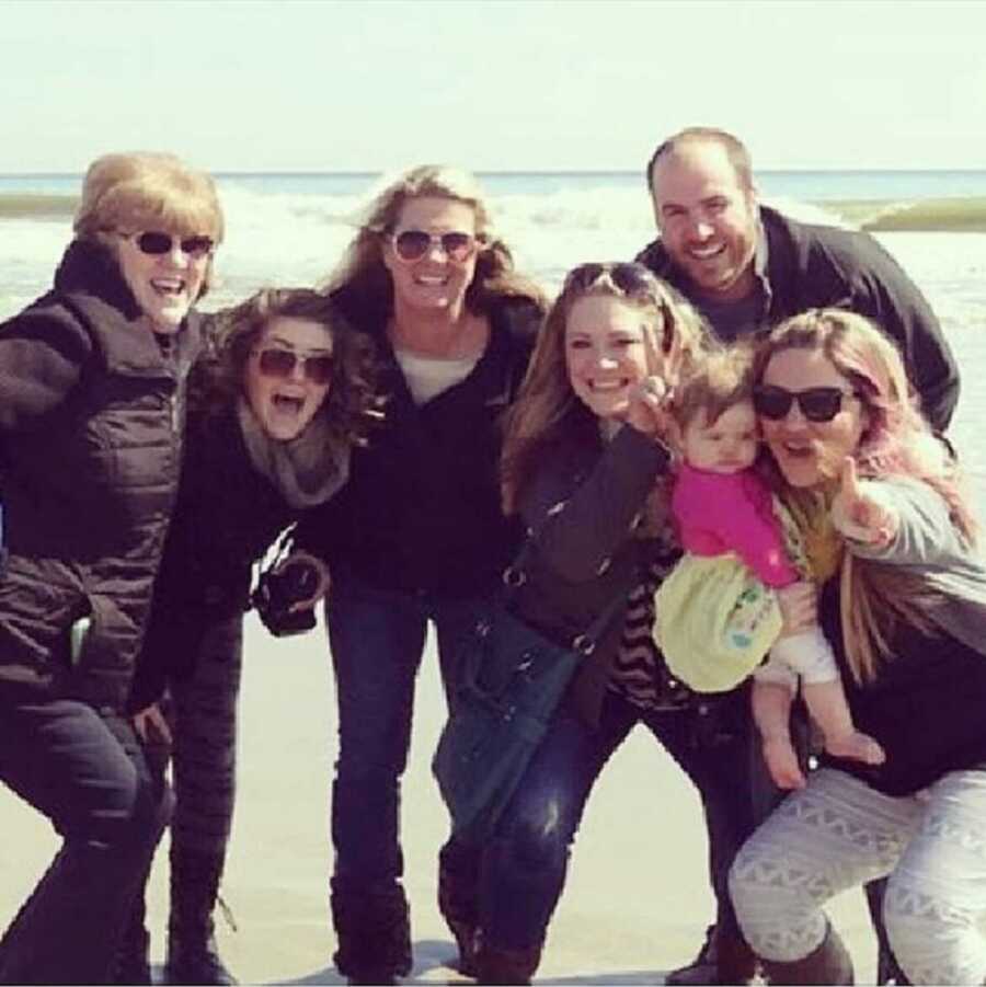 Jessica's family takes a picture together at the coast. 