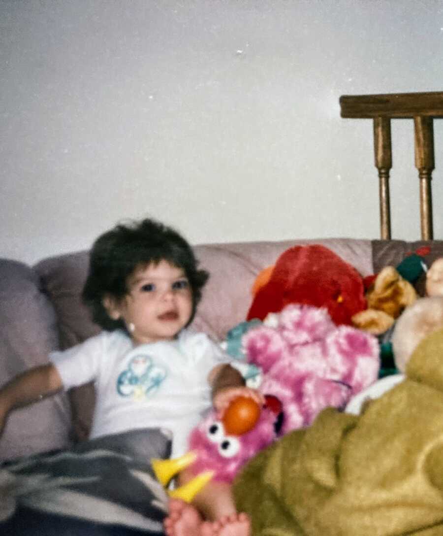 A young girl with Cystic Fibrosis sits with toys