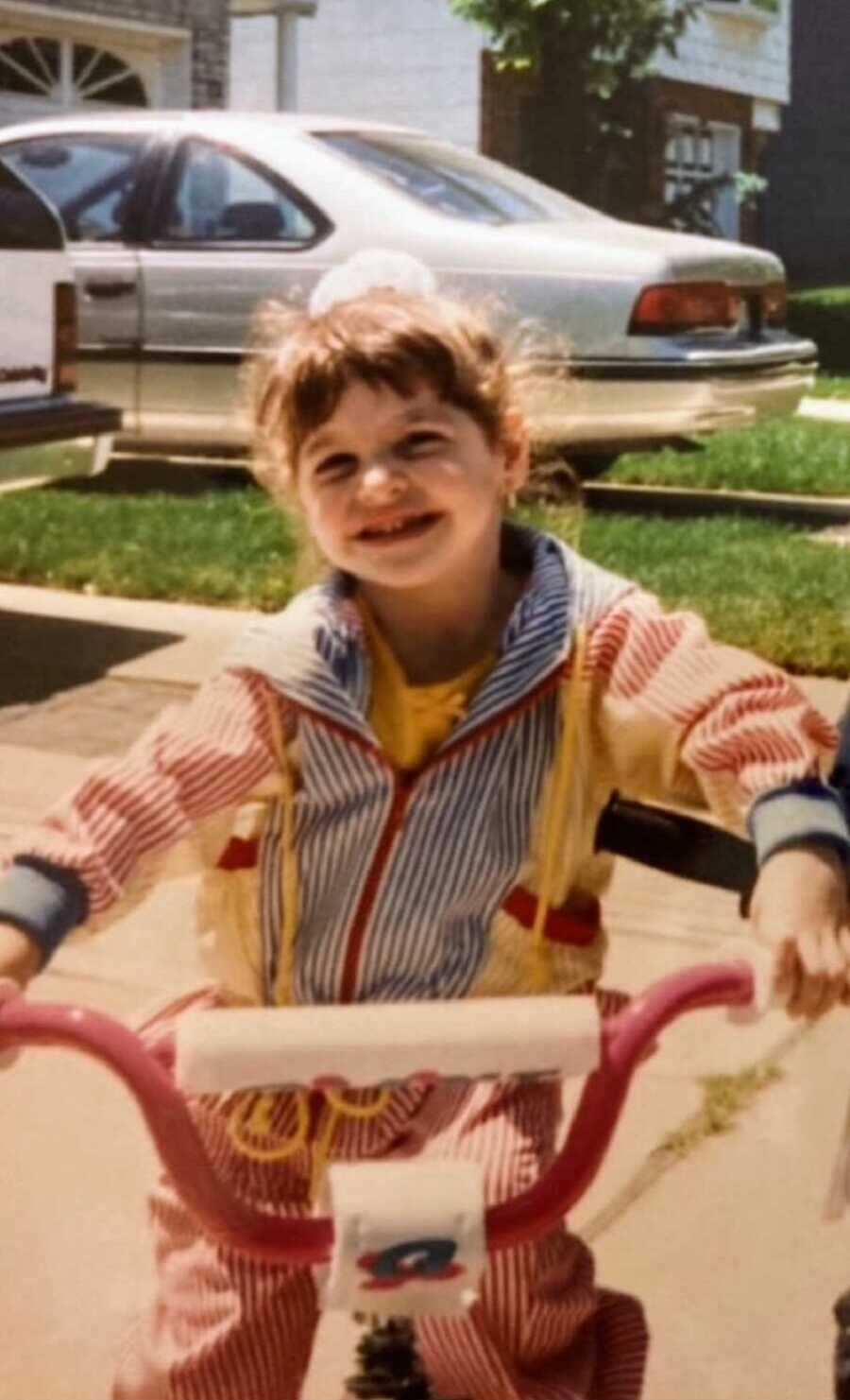 A young girl with Cystic Fibrosis riding a bike