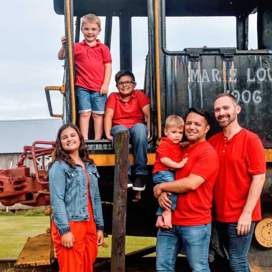 Gay dads with their four children wearing matching colors