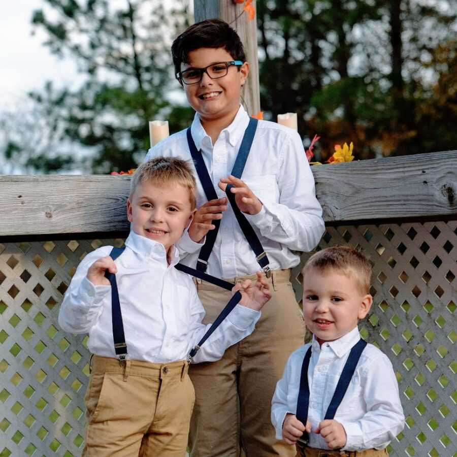 Three brothers together wearing suspenders