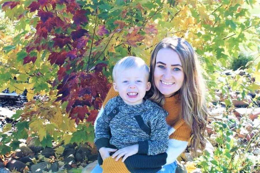 凯琳和她的儿子穿着秋天的毛衣对着镜头微笑。