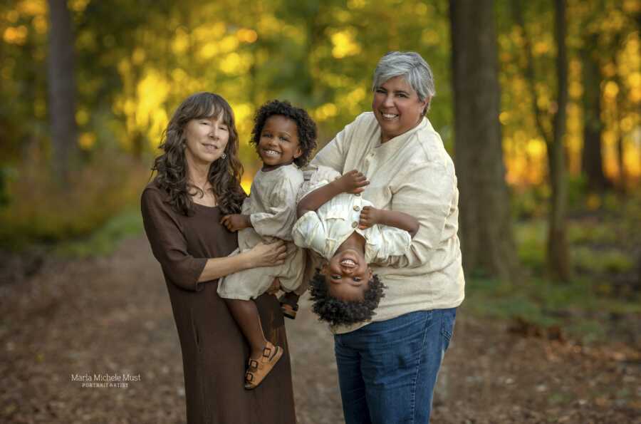 adoptive moms with their twins in the woods