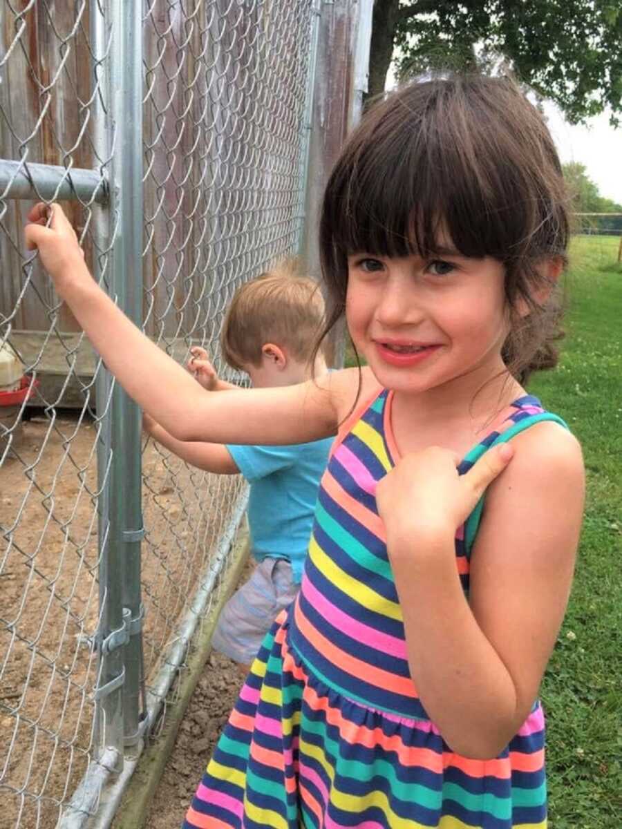 Lola wears a colorful striped dress and smiles at the camera. 