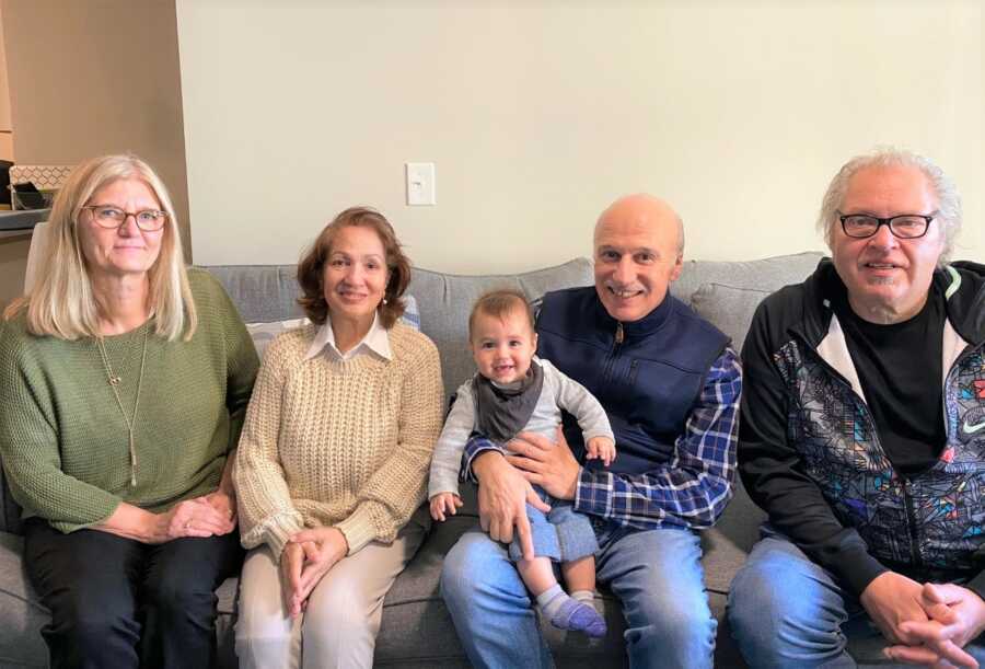 Sami sits with both sets of grandparents for a Halloween visit. 