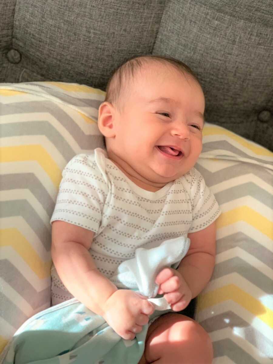 Baby Sami smiling and laughing at the camera. 