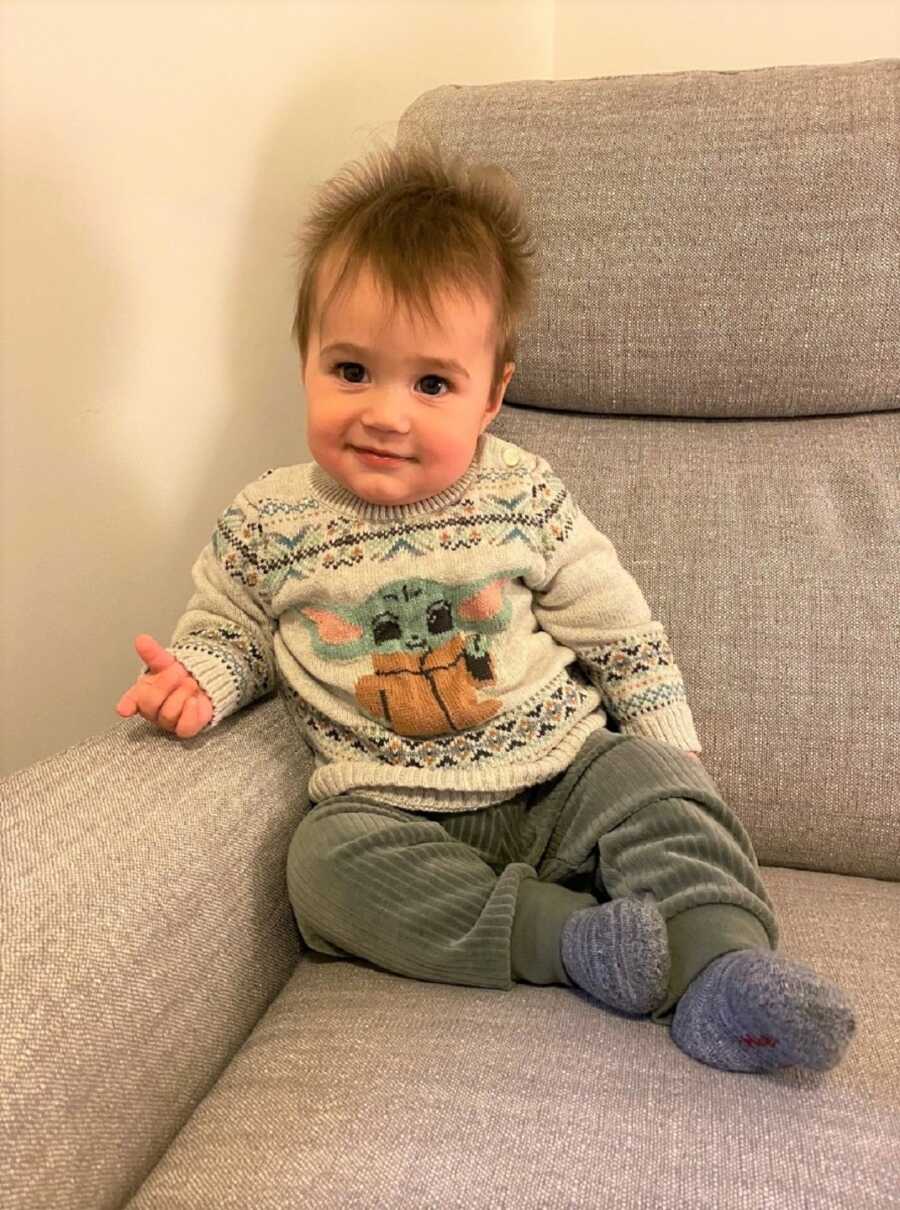 Sami wearing an adorable baby Yoda sweater. 