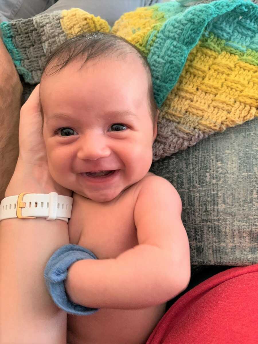 Michelle holds a smiling baby Sami. 