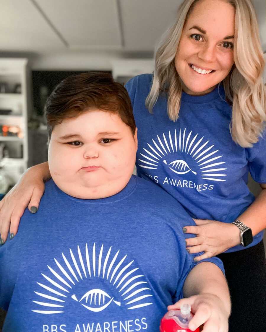 母亲带着儿子，两人都穿着蓝色衬衫，以提高人们对巴德-比德尔综合症的认识