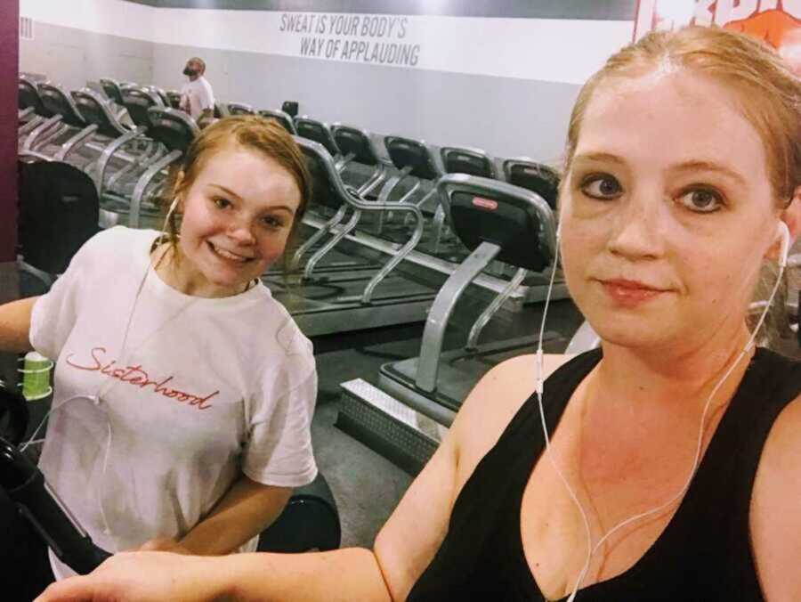 Young mom and daughter exercising at gym together