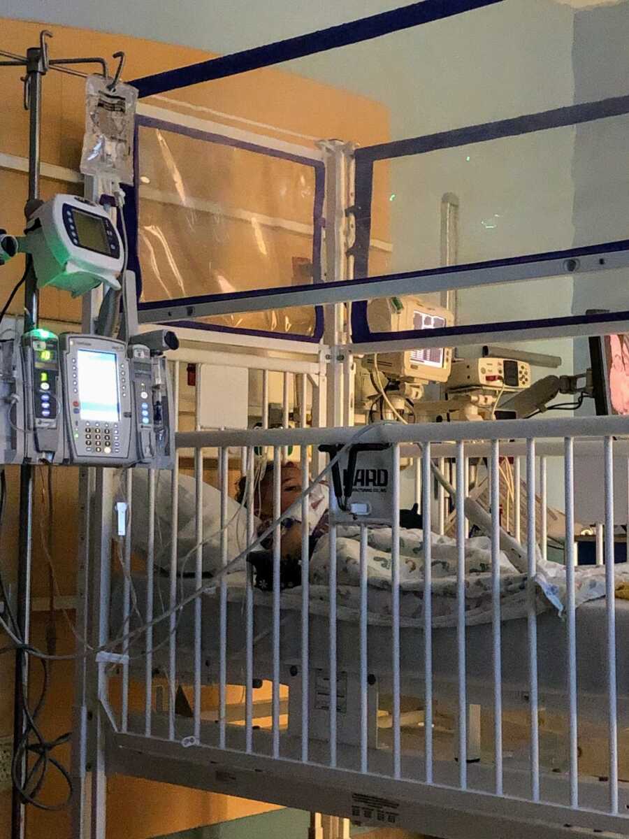 toddler boy in caged bed at hospital 