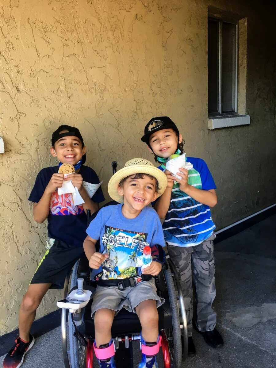 toddler boy in wheelchair around his siblings