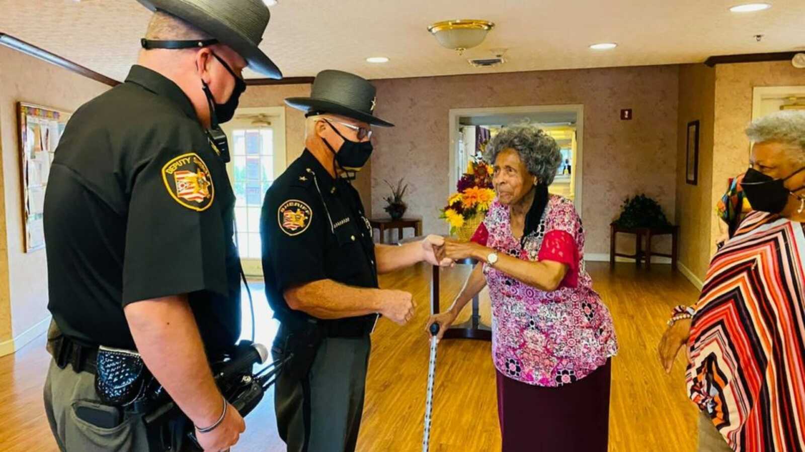 officers visiting the lady who complimented the officer for helping her fix her car
