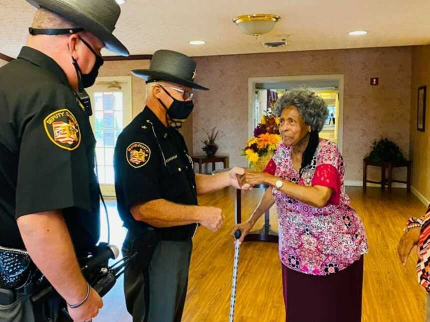 officers visiting the lady who complimented the officer for helping her fix her car