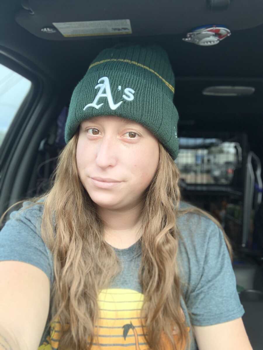 Woman taking selfie in car with beanie on