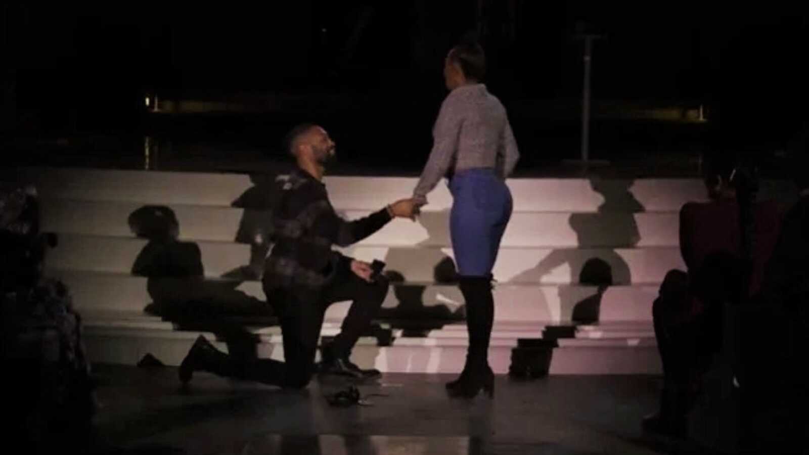 man proposing to his girlfriend at an Adele concert