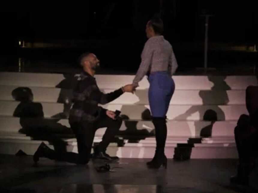 man proposing to his girlfriend at an Adele concert