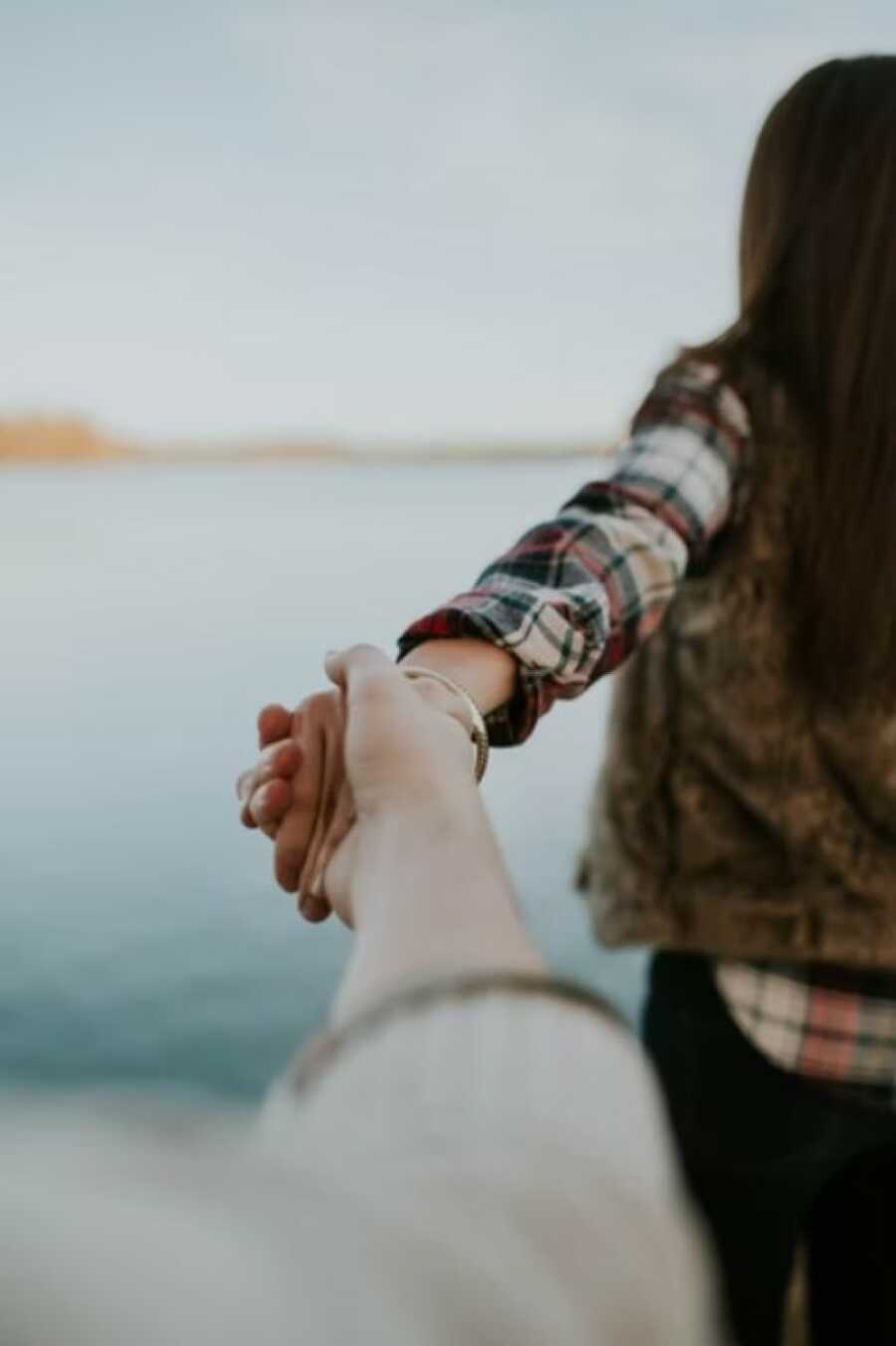 couple doing a popular pose while walking by the water