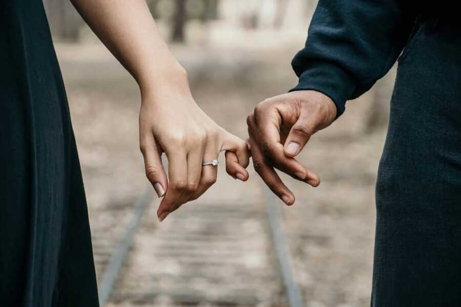 couple linking pinkies to show their unity