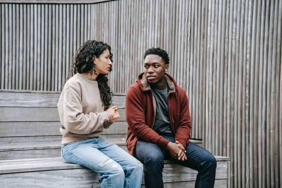 couple sitting on steps about things that they are disagreeing about