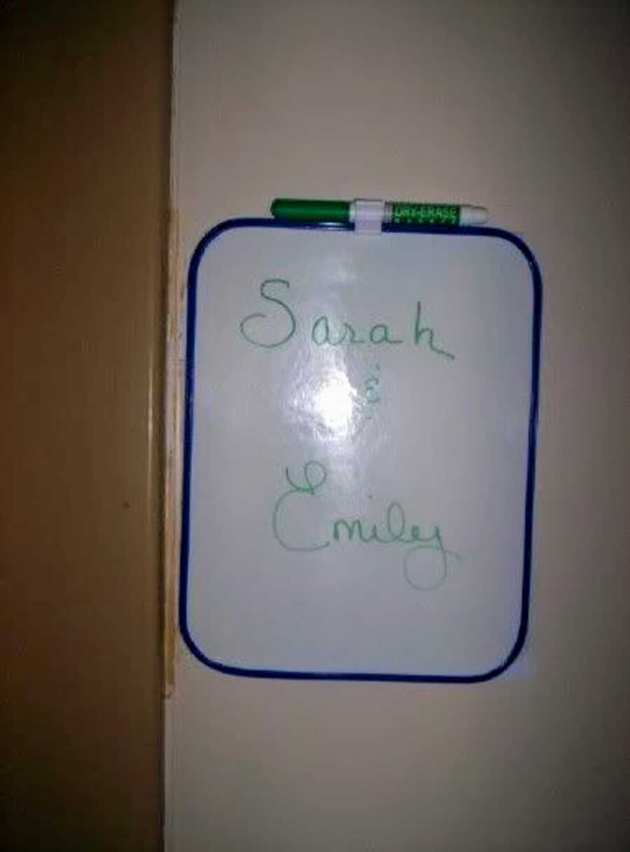 Small whiteboard with the names Sarah and Emily written on it.