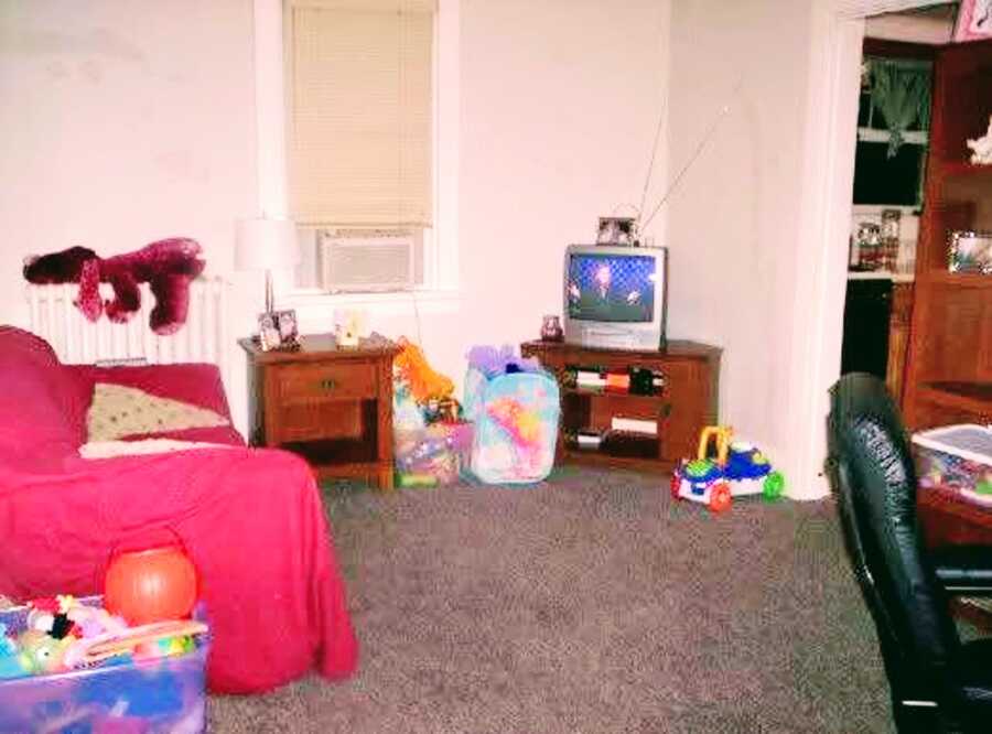 Room with a small television, children's toys, and a couple of chairs.