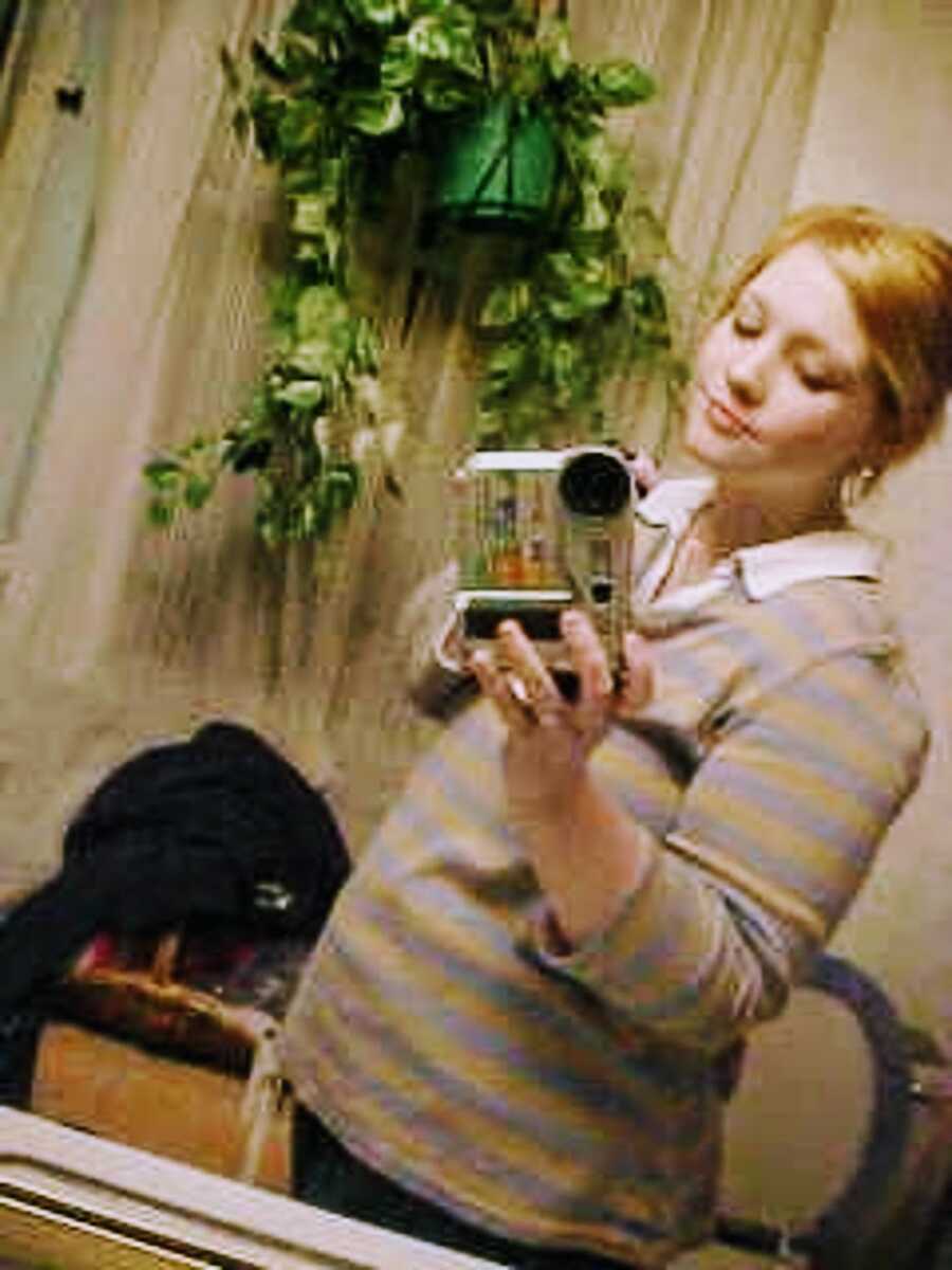 Mother at three months pregnant, taking a selfie in a mirror.