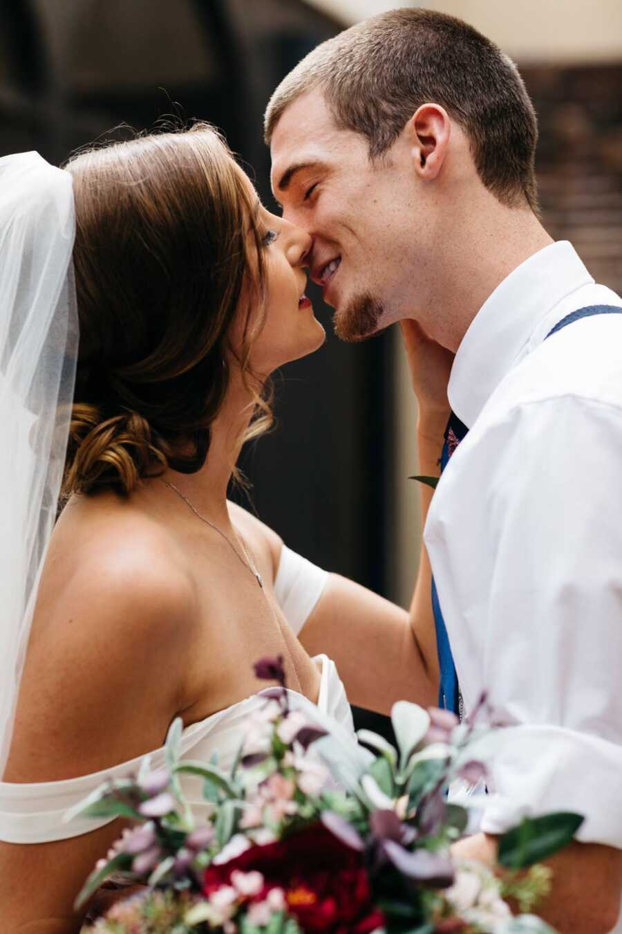 mom and dad on their wedding day about to kiss