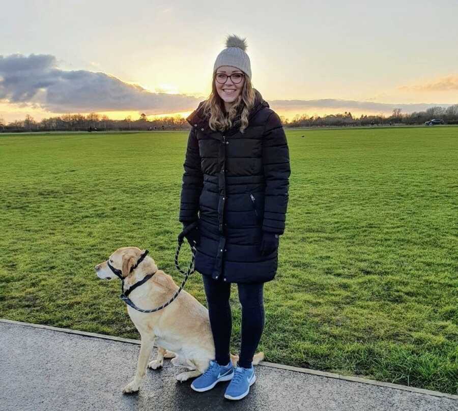 Autistic woman standing with a dog on a leash