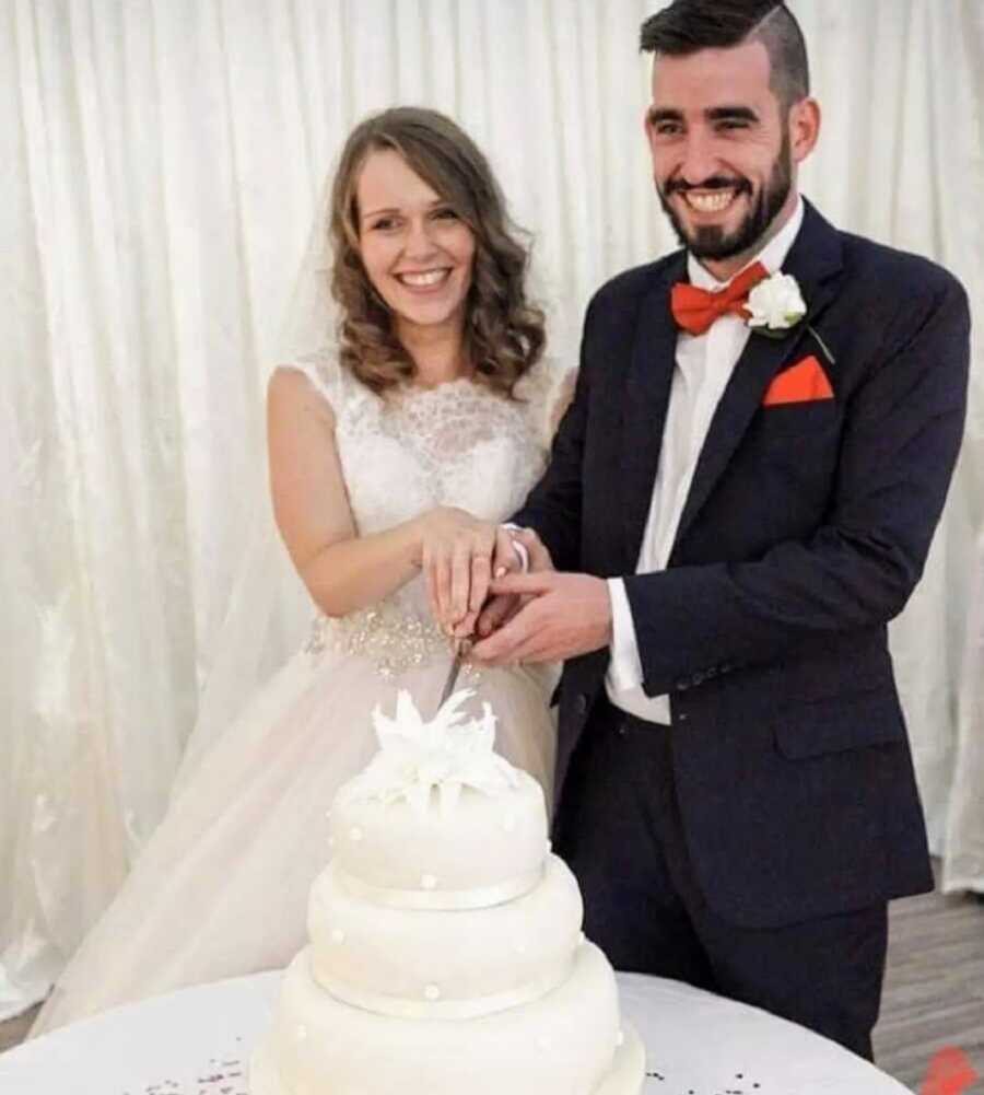 A bride and groom cut their cake at their wedding