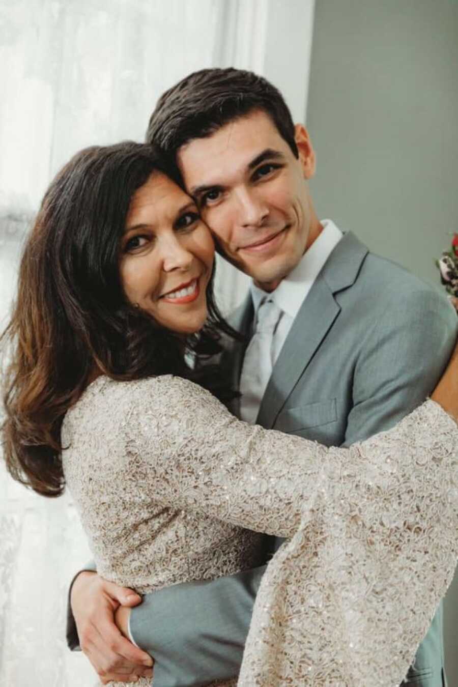 mom holding her son close on his wedding day for the photographer