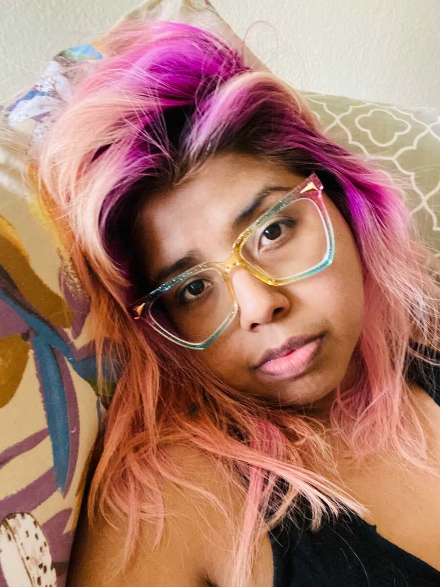 woman with pink hair and glasses