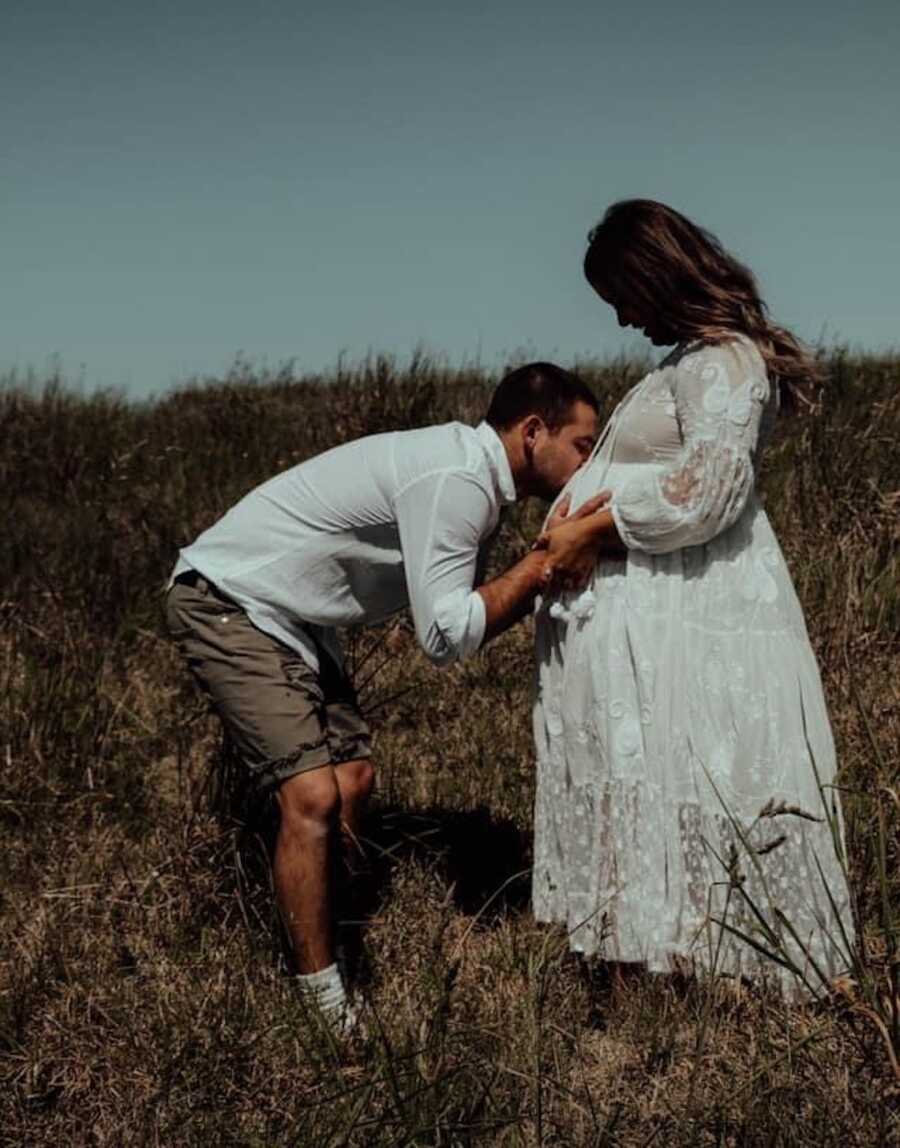 maternity photo of woman in white dress in a field