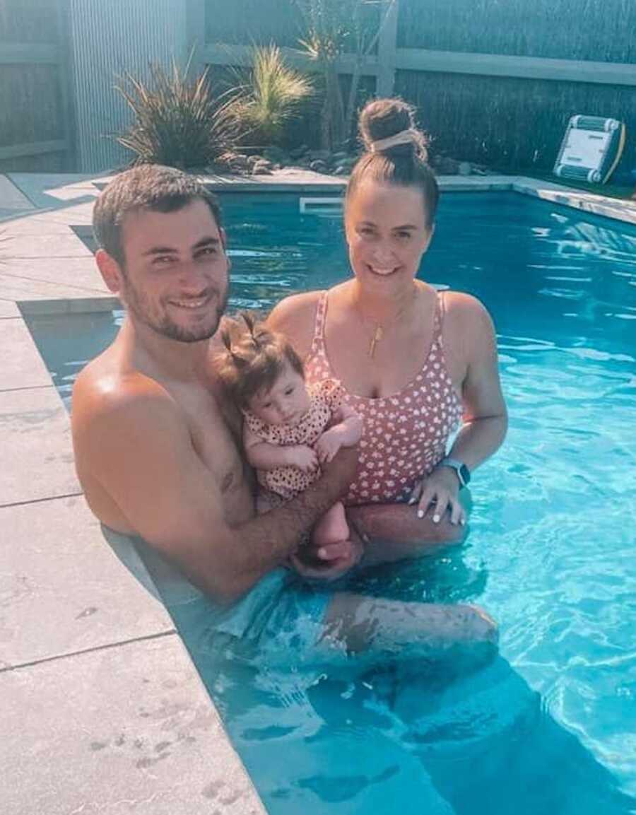 parents in the pool with their daughter