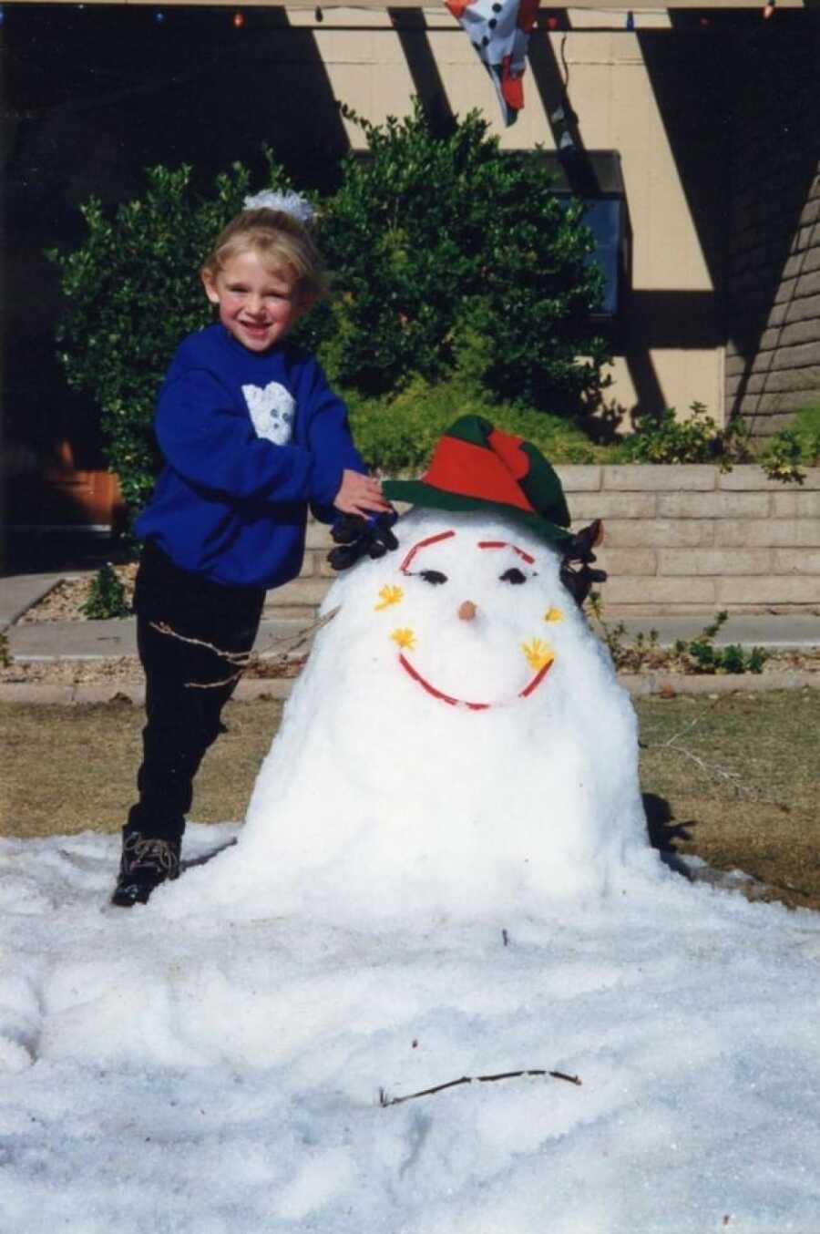 little kid in the winter building a snowman
