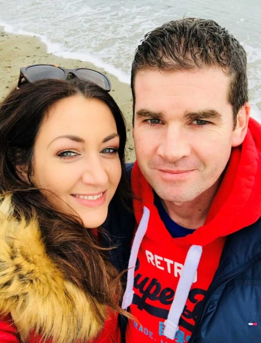 mom and dad taking a selfie on a beach