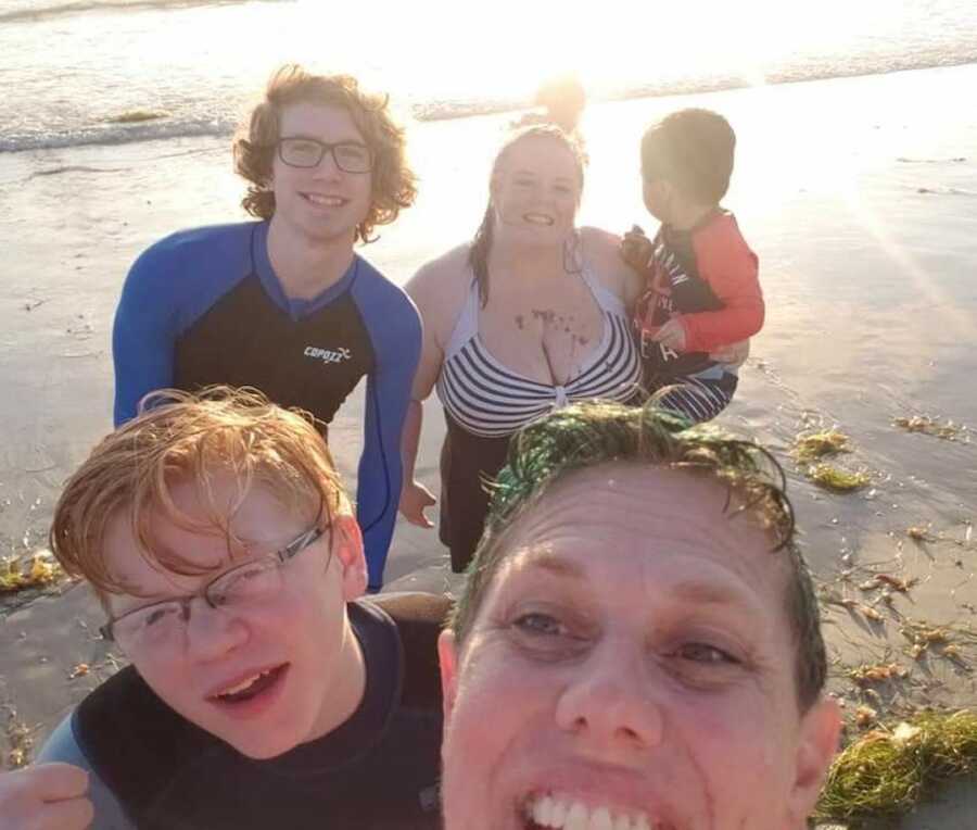 family smiling on the beach