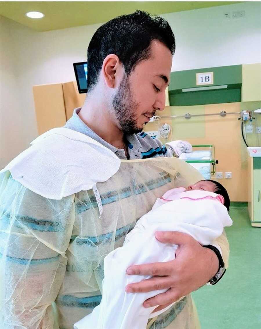 Dad holds his newborn daughter in the hospital