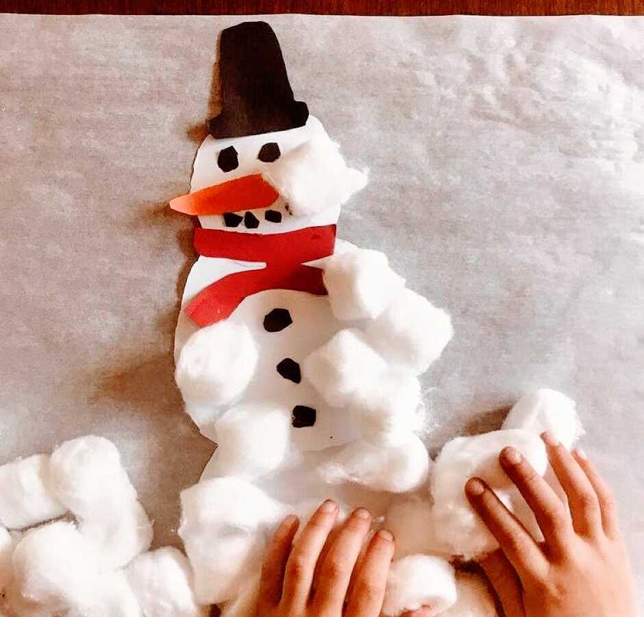 Mom takes a photo of her child doing a DIY snowman craft in honor of the holiday season