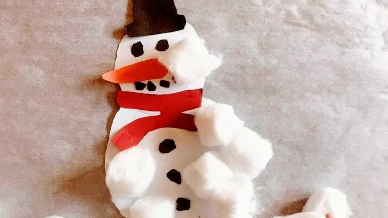 Mom takes a photo of a DIY snowman craft she did with her son