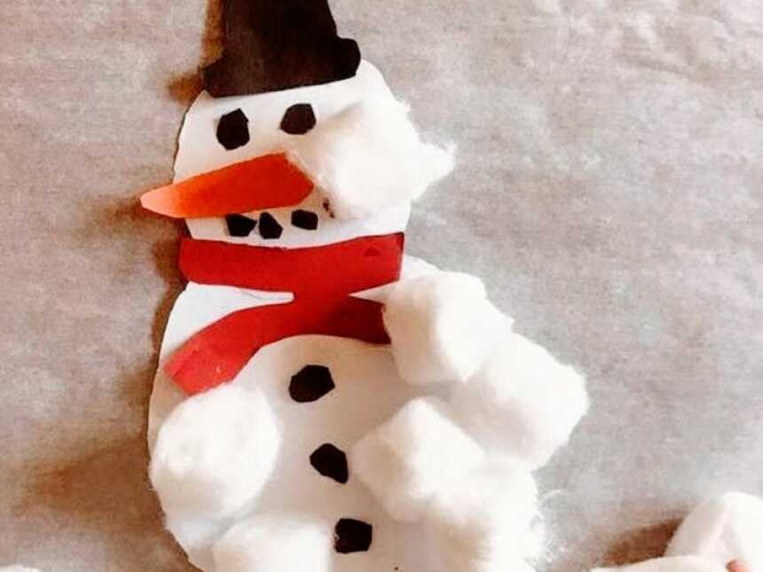 Mom takes a photo of a DIY snowman craft she did with her son