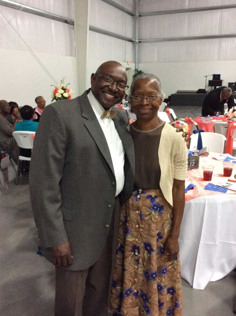 elderly couple in church clothes posing for a picture