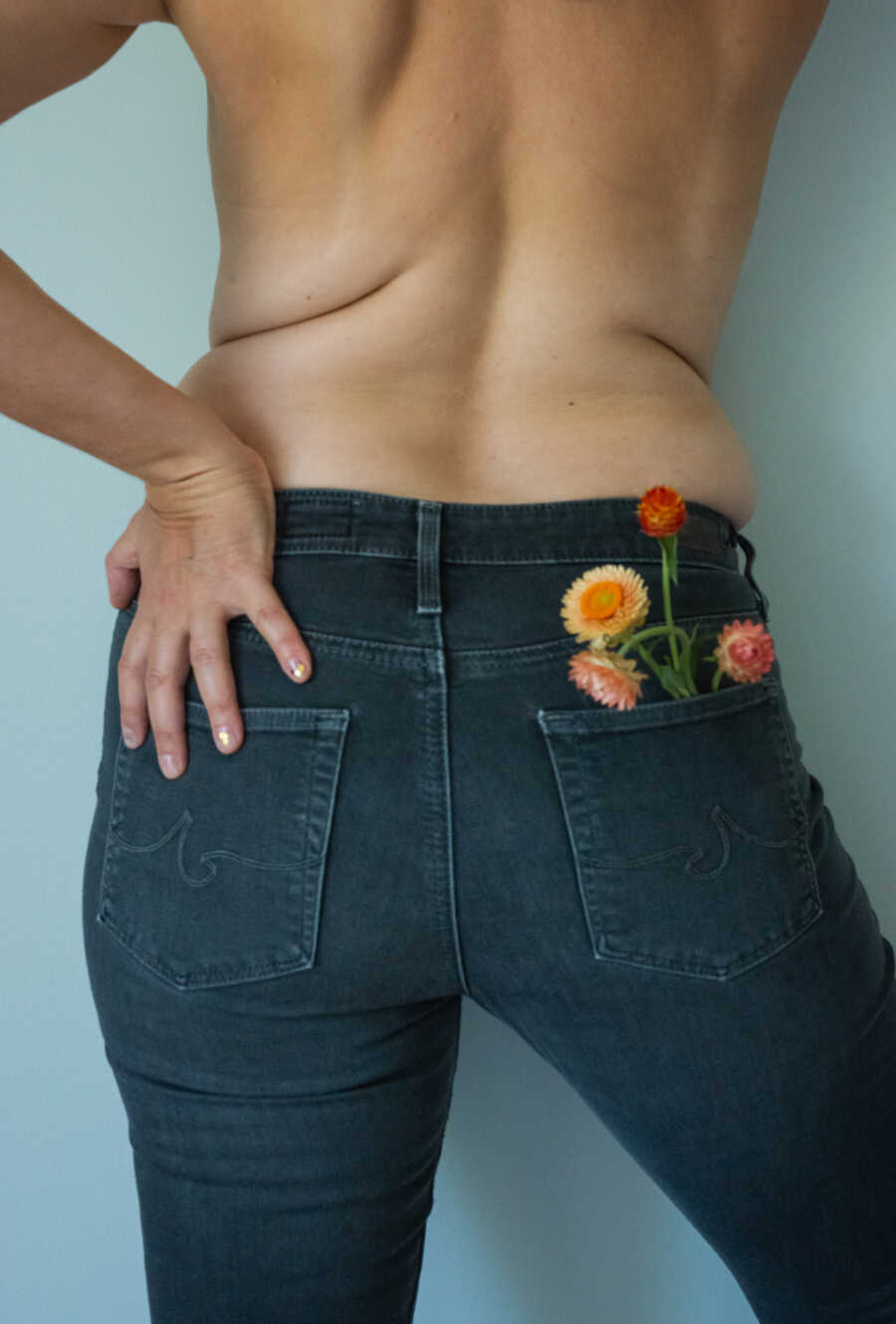 photo of woman in jeans with flowers in pocket