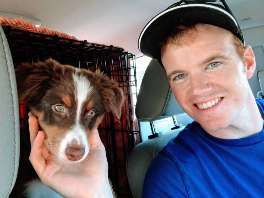 Man takes a selfie in his truck with his new dog