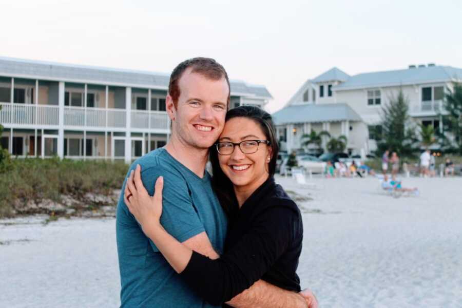 Newly engaged couple take photo together on the beach